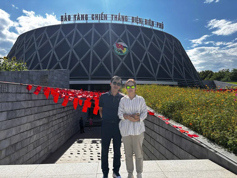A couple poses in front of the Dien Bien Phu Victory Museum with its distinctive geometric facade in Dien Bien Phu.